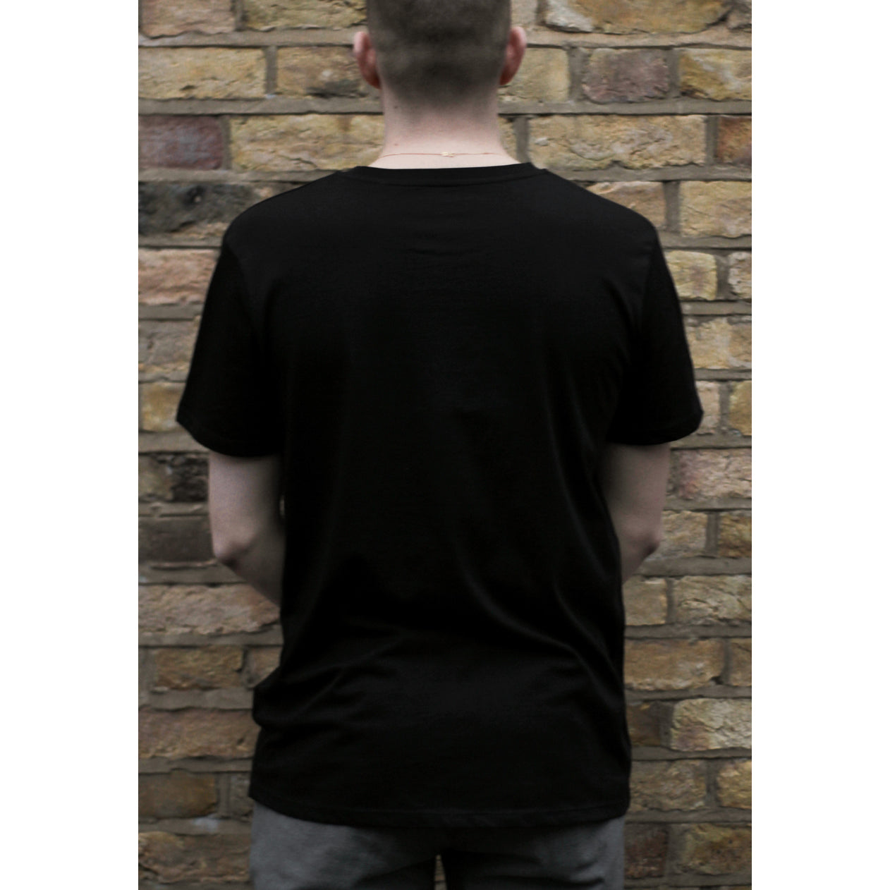 Back of man wearing black organic cotton short sleeve t-shirt